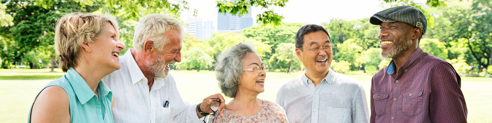 A group of senior men and women standing outdoors laughing and talking