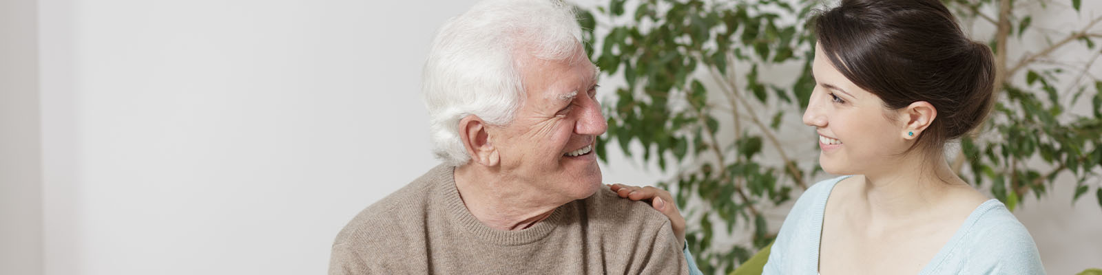 A senior man looking over at his grand daughter while smiling