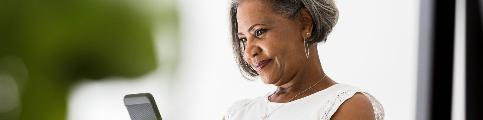 A senior woman looking down at her smartphone